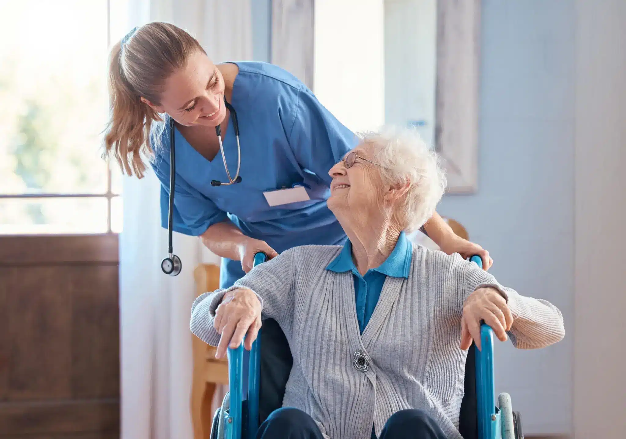 a nurse pushing an old woman in a wheelchair