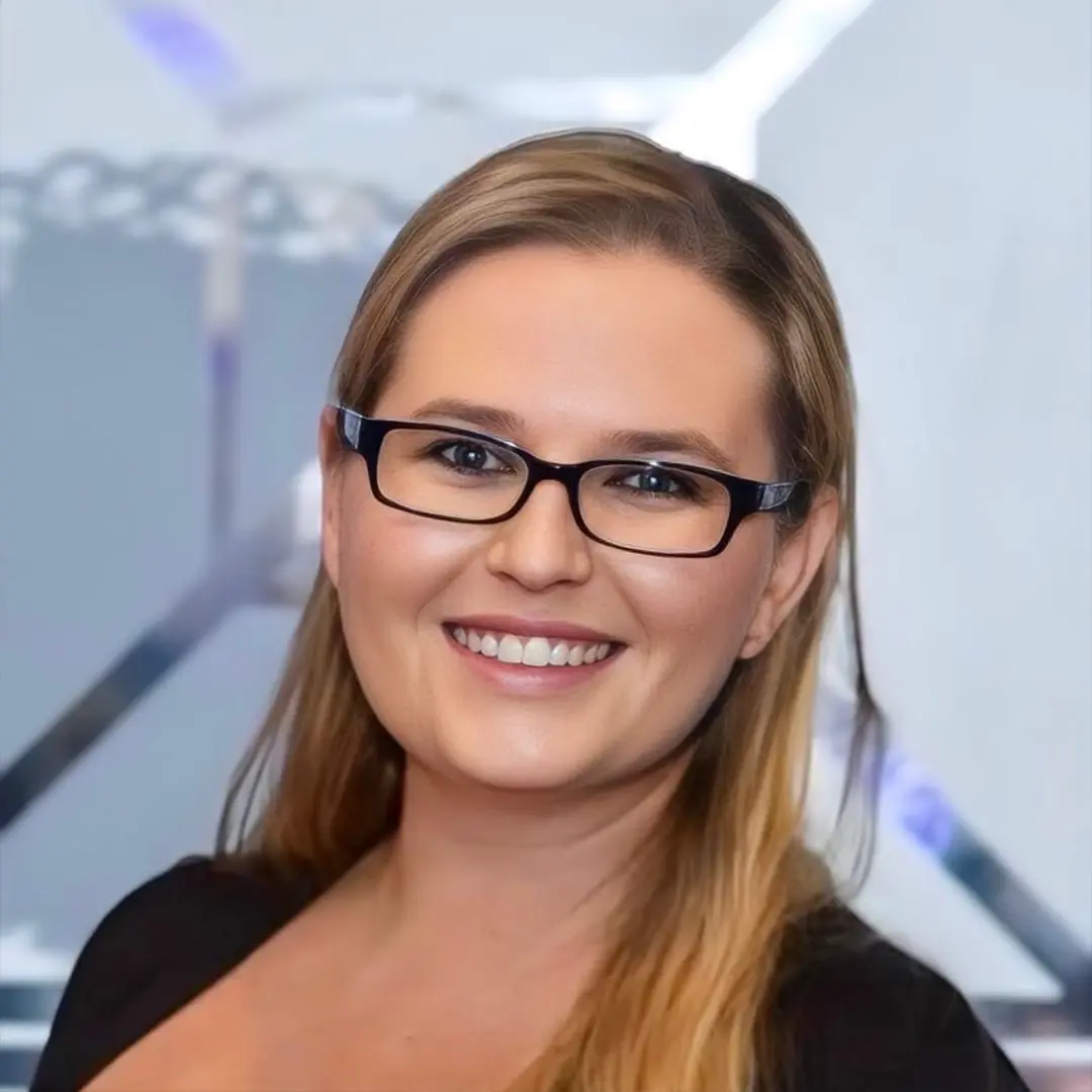 a woman wearing glasses and smiling